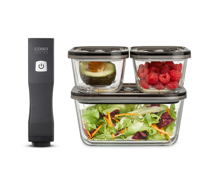 Ein CASO Vacu OneTouch Handvakuumierer neben drei Glasbehältern mit dunklen Deckeln. Zwei kleinere Behälter mit Avocadohälfte und Himbeeren stehen auf einem größeren Behälter mit Salat.