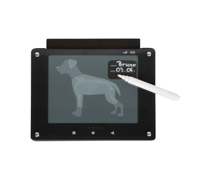 Ein schwarzes Tablet aus dem small foot Tierarzt-Set »Hund« zeigt ein Röntgenbild eines Hundeskeletts. Ein weißer Stift schreibt „Bruno“ und „03.06.“ auf den Bildschirm.