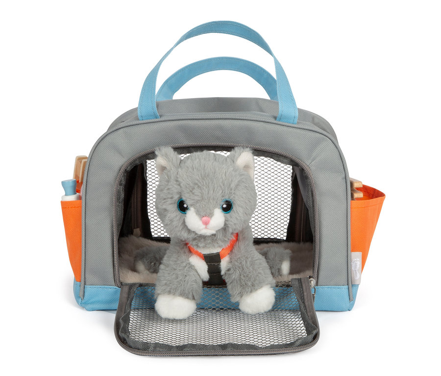 Eine graue Stoffkatze sitzt in einer grauen Tasche mit blauen Griffen und orangefarbenen Seitentaschen, es handelt sich um die small foot Katze mit Tasche und Pflege-Set.