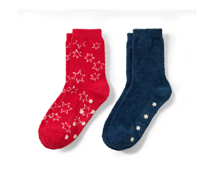 Zwei Paar Kinder-Kuschelsocken: ein Paar rot mit weißen Sternen, ein Paar blau mit weißen Sternen.