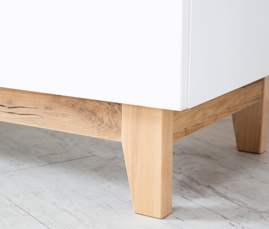 Detail einer Ecke der weißen Roba Wickelkommode »Finn« mit Holzbeinen.