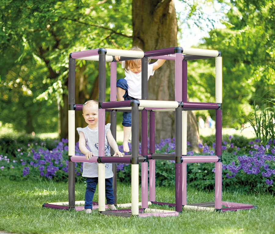 Zwei Kinder spielen auf einem farbenfrohen Quadro-Home-KLETTERPYRAMIDE, berry auf einer Wiese.