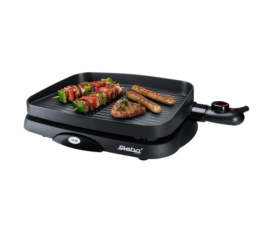Auf einem schwarzen Grill liegen ein Schaschlik, ein Steak und zwei Würste. Zu sehen ist außerdem ein Steba-BBQ-Grill »VG 90 compact«.