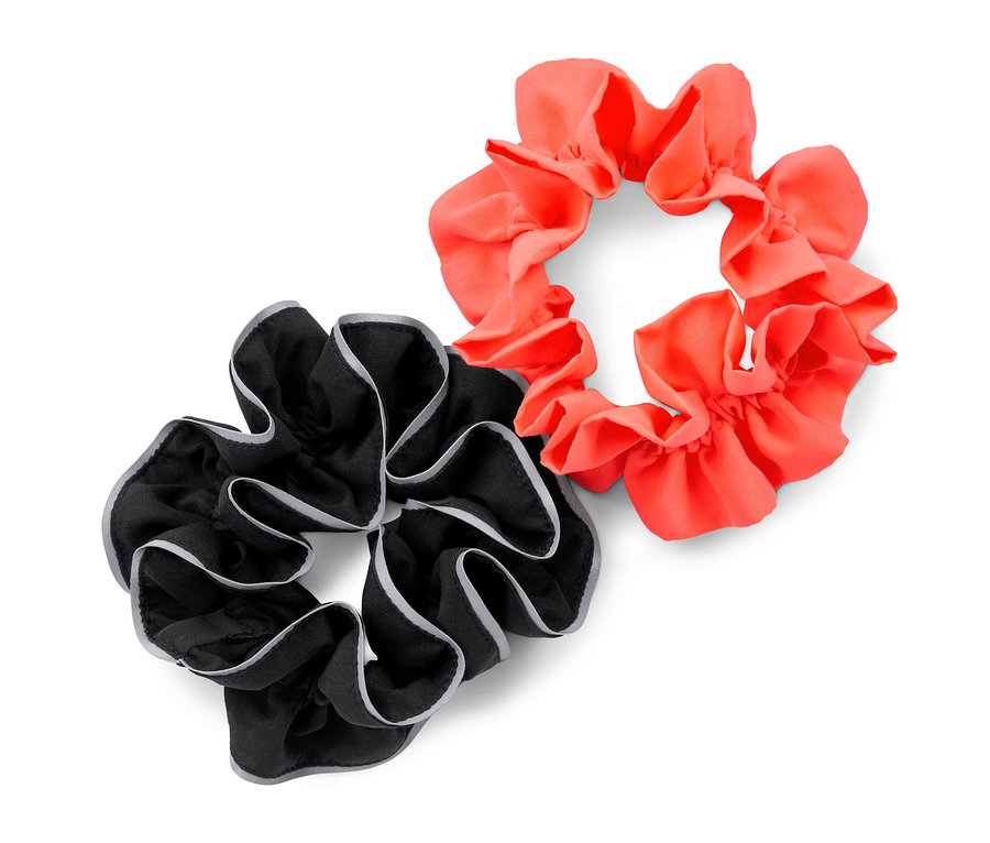 Zwei Sport-Haarbänder, eines schwarz mit grauem Rand und eines korallenfarben.