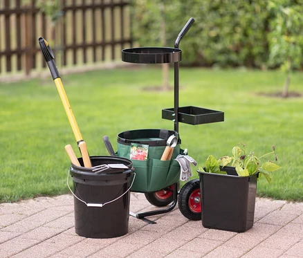 Universal-Garten-Trolley mit Gartengeräten steht auf einer Fliesenterrasse, daneben ein Eimer und ein Blumentopf.