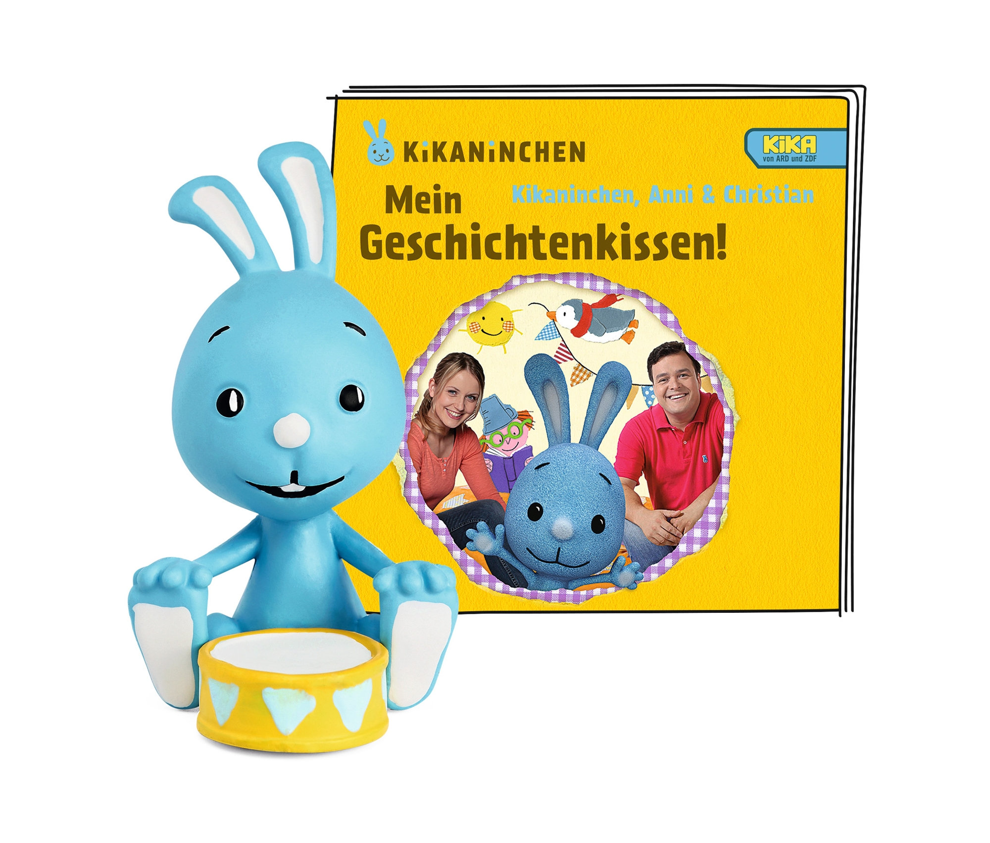 Eine blaue Kikaninchen-Figur sitzt hinter einer gelben Trommel vor der Kikaninchen-Produktverpackung.