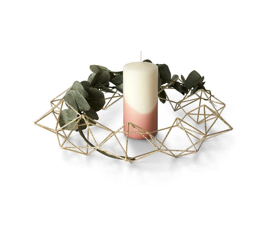 Ein Deko-Kranz mit einer zweifarbigen Kerze und grünen Blättern.