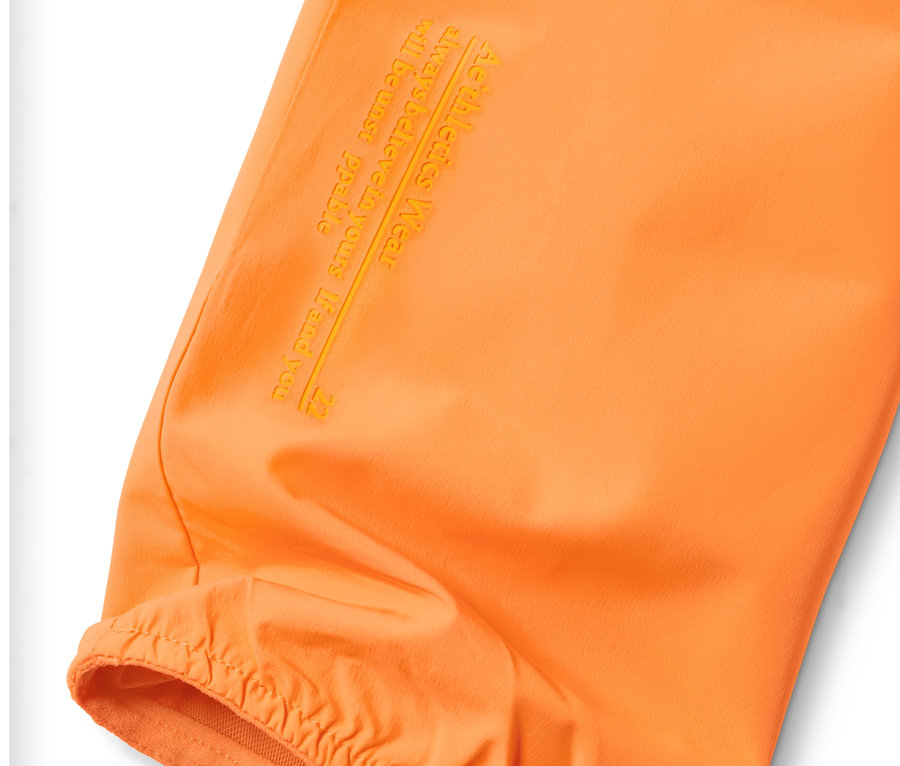 Detailansicht einer neonorangen Windprotection-Jacke.