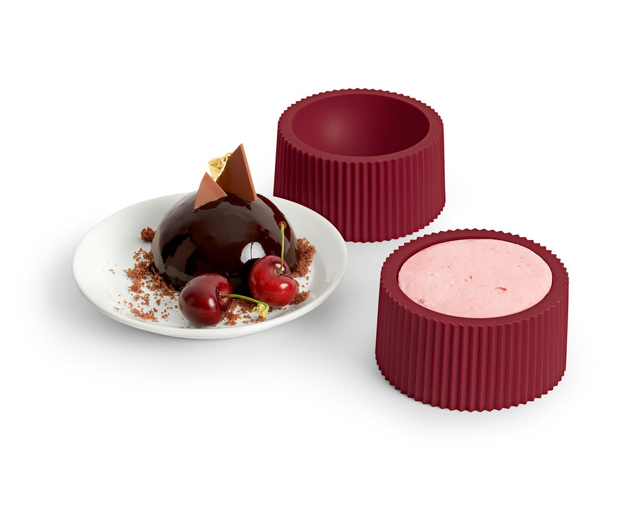 Schokoladenkugel mit Kirschen auf Teller neben 4 Dessert-Formen.