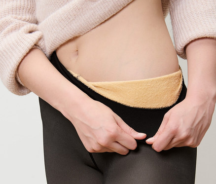 Frau zieht gefütterte Feinstrumpfhose in transparenter Optik an.