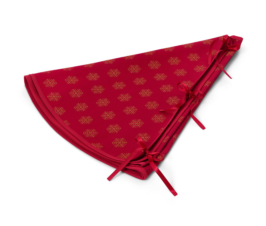 Eine rote Tannenbaumdecke mit goldenem Schneeflockenmuster.
