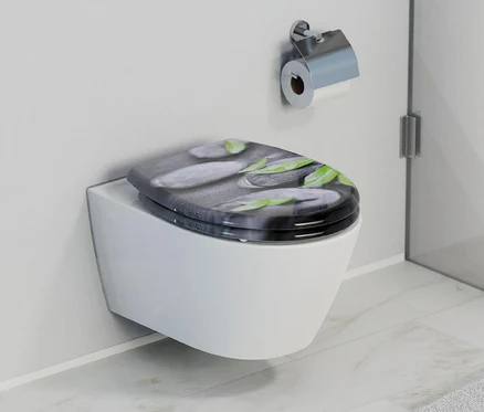 Weiße Toilette mit Duroplast WC-Sitz Stone mit Stein- und Blattmotiv.