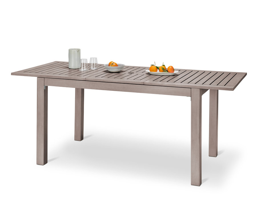 Ein Ausziehtisch »Leira« mit Sonnenschirm-Aussparung, darauf Vase, Gläser und Früchte.