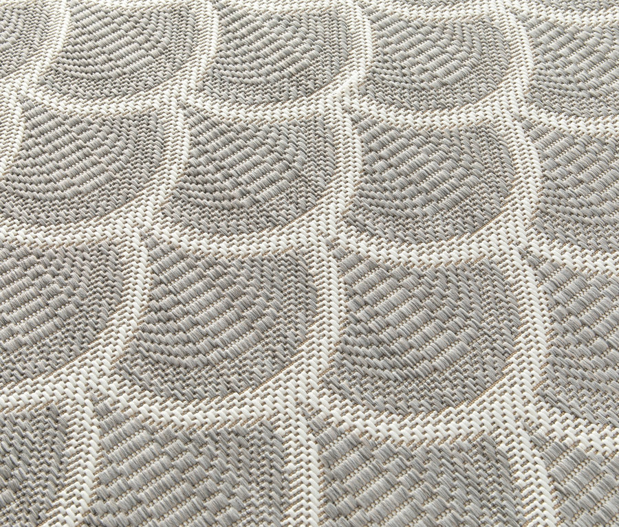 Nahaufnahme eines beigen Outdoor-Teppichs »Arcs« mit geometrischem Muster.