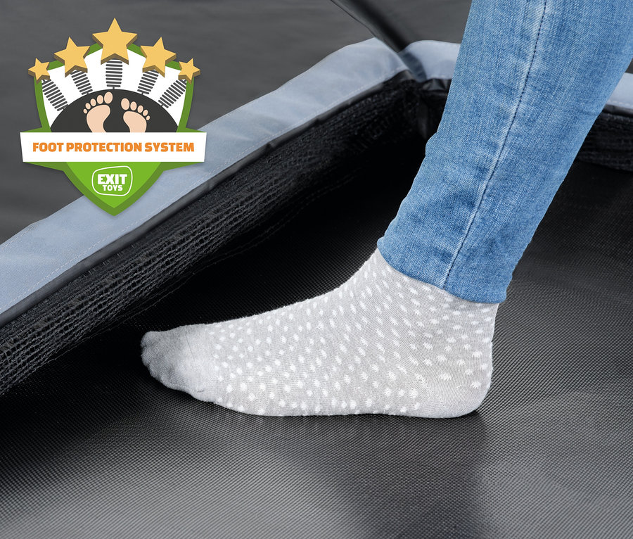 Ein Fuß in einer Socke mit Antirutschbeschichtung steht auf dem EXIT Dynamic Bodentrampolin.