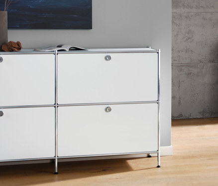 Wohnzimmer mit weißem Sideboard »CN3« mit 6 Klappen, anthrazitfarbenem 3-Sitzer-Sofa, weißer Tischleuchte mit Textilschirm und weißem Couchtisch mit Rollen »CN3«.