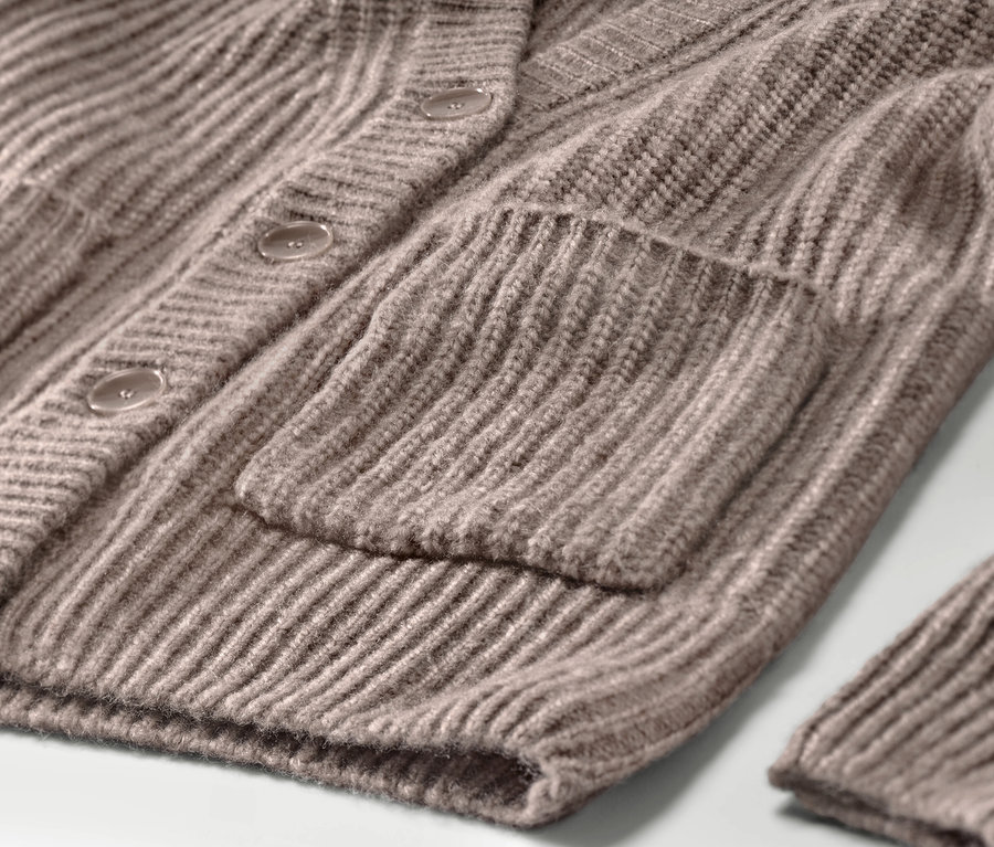 Detailansicht eines taupefarbenen, gerippten Grobstrick-Cardigans mit Tasche und Knöpfen.