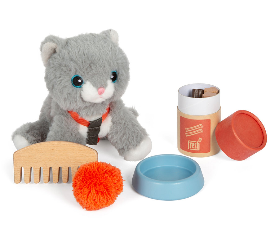 Graue small foot Plüschkatze mit Tasche, Kamm, orangefarbener Bommel, Napf und Behälter mit Deckel, alles auf weißem Hintergrund.