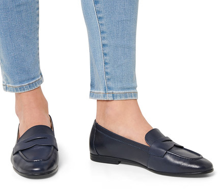 Beine in Jeans und Leder-Loafer.