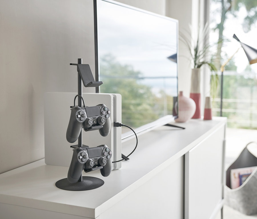 Auf einer weißen Kommode steht ein schwarzer YAMAZAKI Controller-Ständer »SMART« mit zwei Controllern.