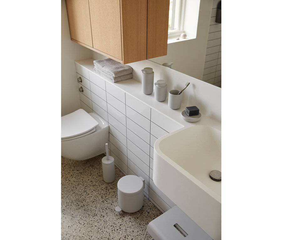 Badezimmer mit Waschbecken, Toilette, Holzschrank und hellgrauem ZONE DENMARK Seifenspender »Ume«.