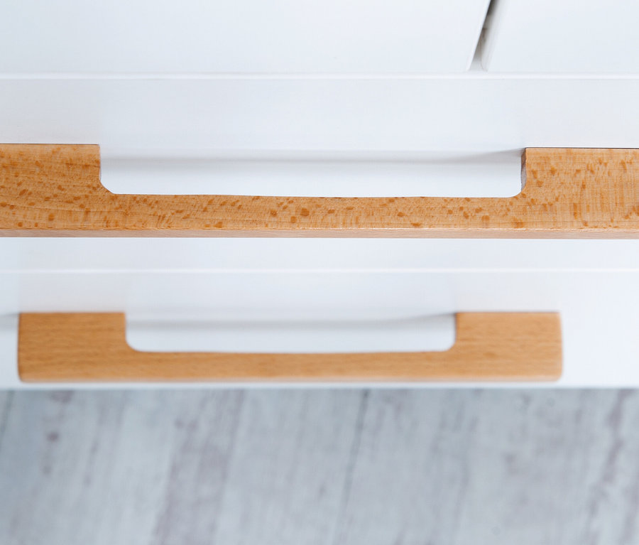 Detail eines weißen Möbels mit zwei hölzernen Schubladengriffen. Zu sehen ist ein Teil des roba »Finn« Kinderzimmersets.