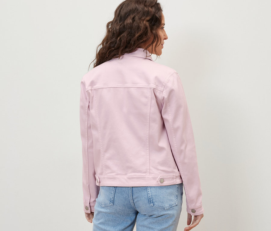 Frau trägt eine Jeansjacke und Jeans.