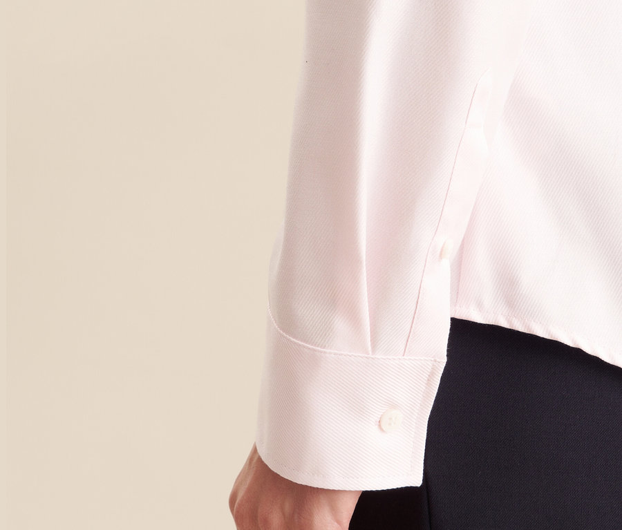 Detailansicht einer rosa Seidensticker Twillbluse am Arm einer Frau.