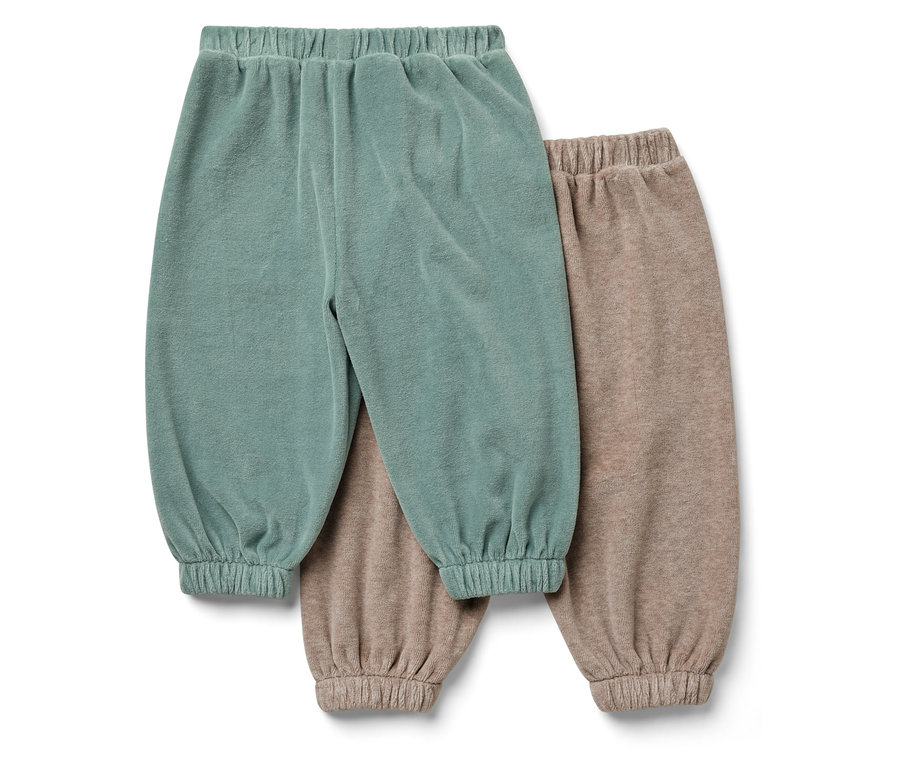Zwei Kinderhosen: eine blaugrüne, die andere beige.
