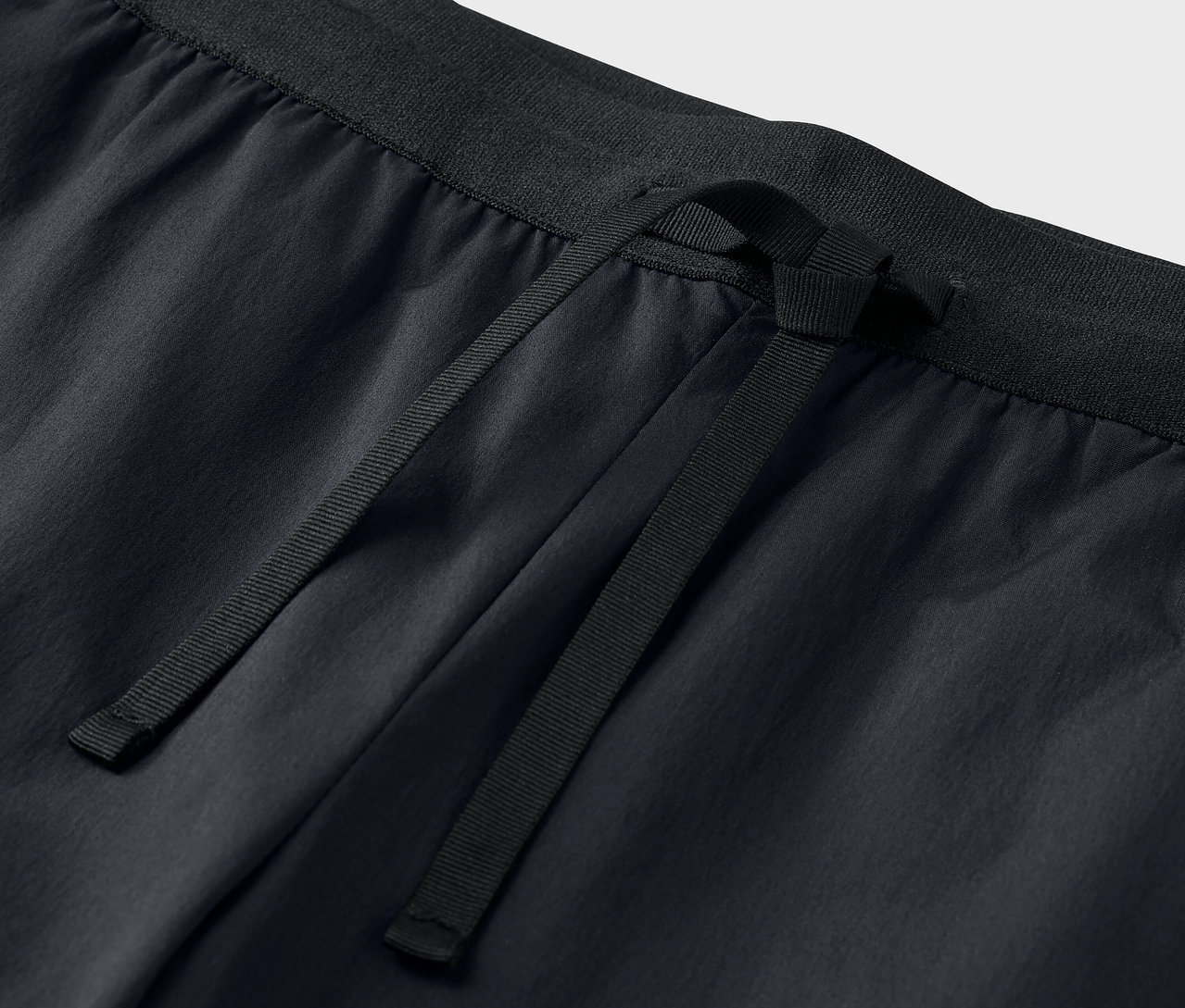 Nahaufnahme einer schwarzen Funktionshose mit Kordelzug.