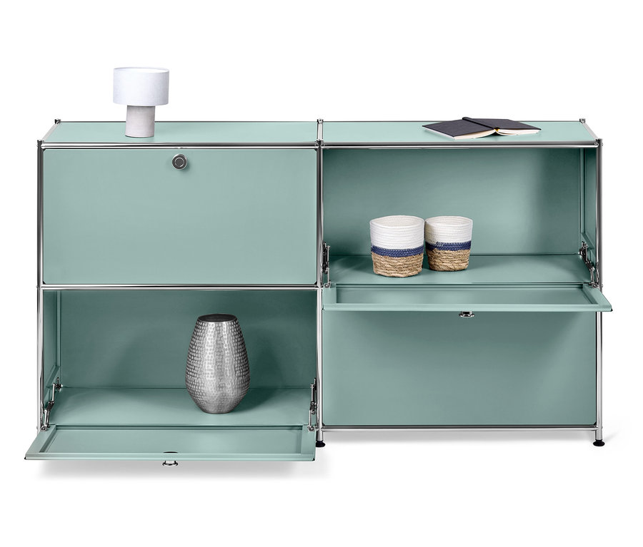 Türkisfarbenes modulares Schranksystem mit silberner Vase, zwei Körben und Lampe.
