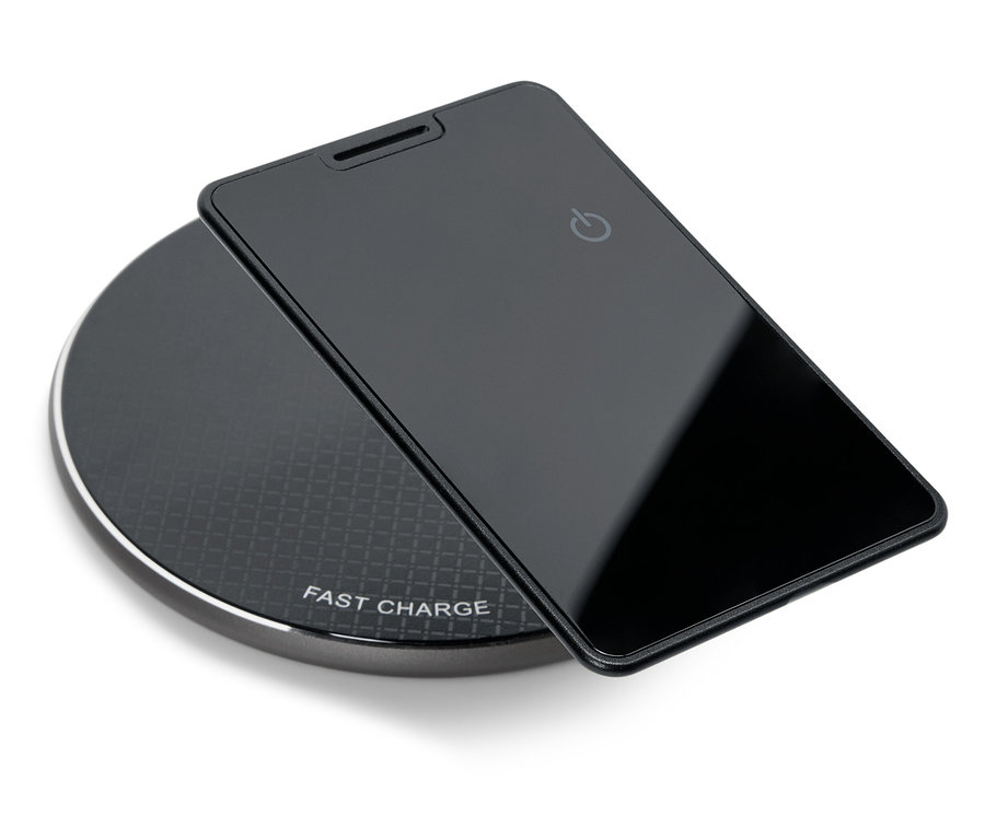 Ein schwarzes Smartphone liegt auf einem schwarzen, runden, kabellosen Ladegerät.