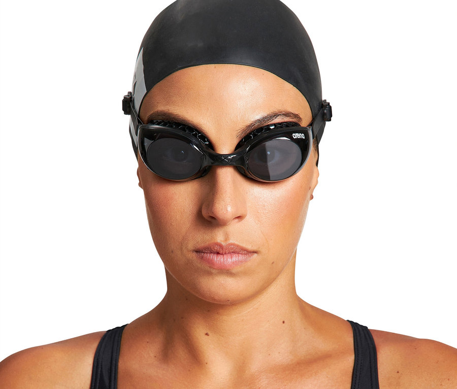 Frau trägt schwarze Badekappe und schwarze arena Air Soft Schwimmbrille, blickt nach vorne.