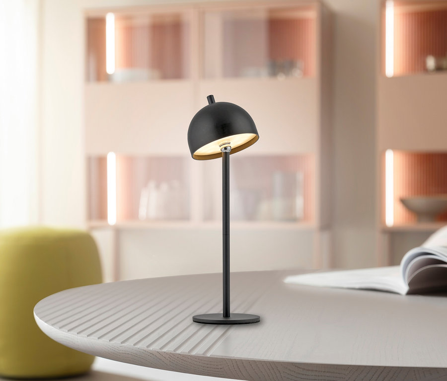 Eine schwarze Lampe steht auf einem Tisch.