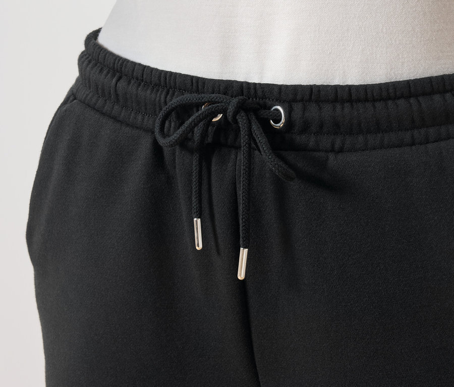 Detailaufnahme einer schwarzen Jogginghose mit Kordelzug in der Taille.