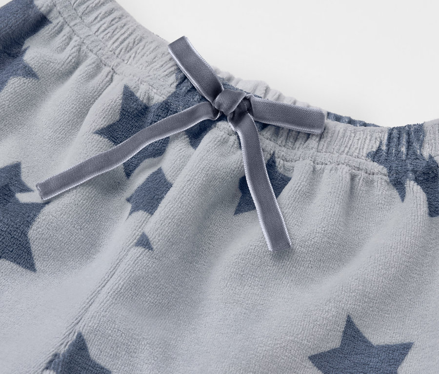 Detail einer grauen Sternenhose mit Schleife.