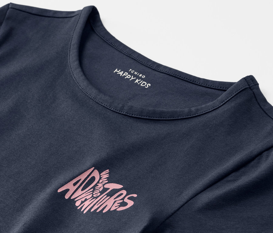 Detailaufnahme eines blauen Kinder-T-Shirts mit dem Aufdruck "Adventures".