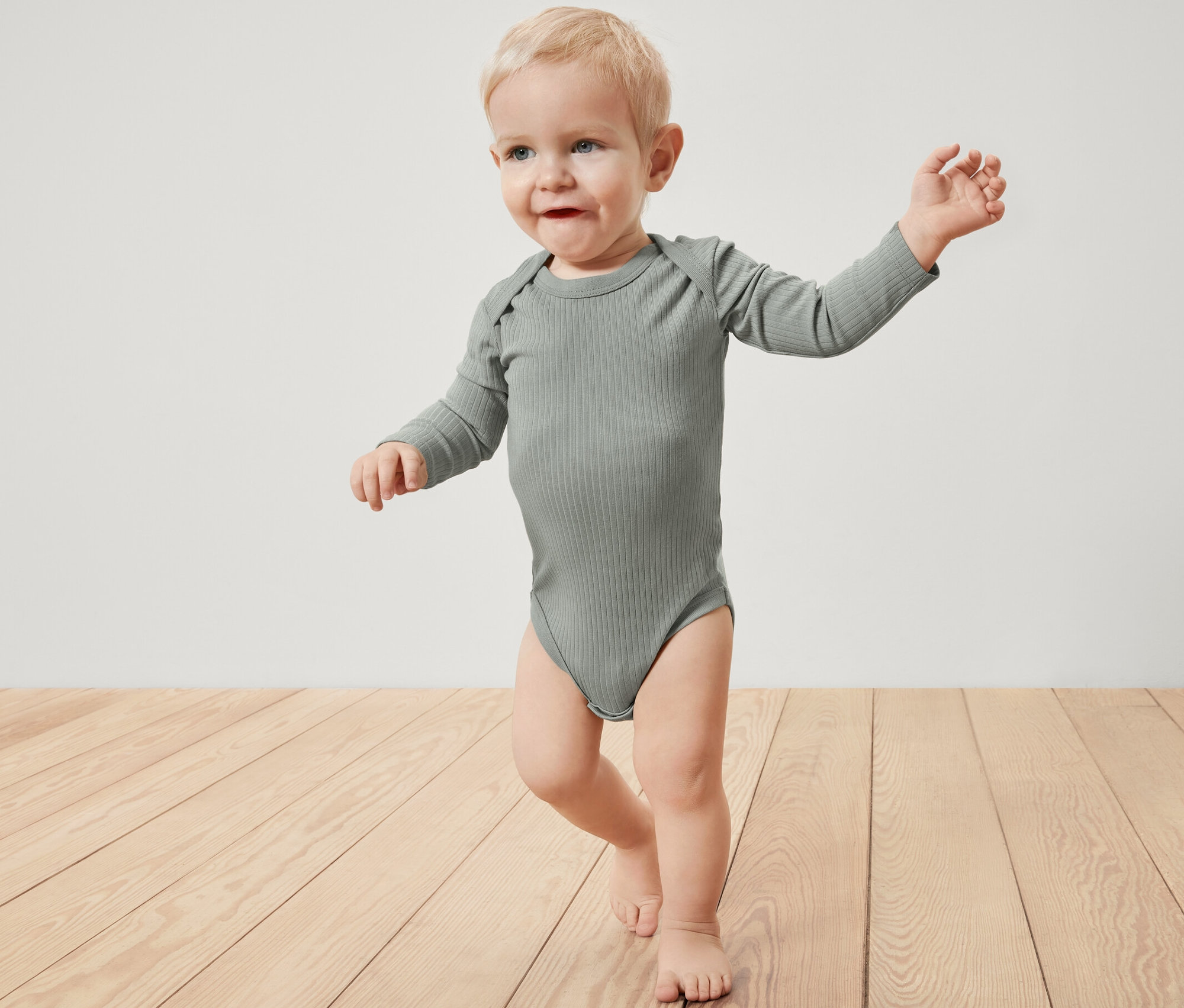 Kleinkind trägt einen gerippten Langarmbody.