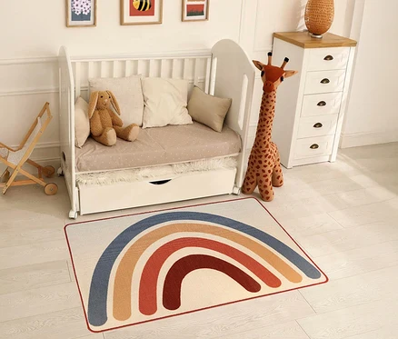 Ein Kinderzimmer mit einem weißen Kinderbett, einer Spielzeuggiraffe und einem »Rainbow« Kinderteppich im Vintage-Stil.
