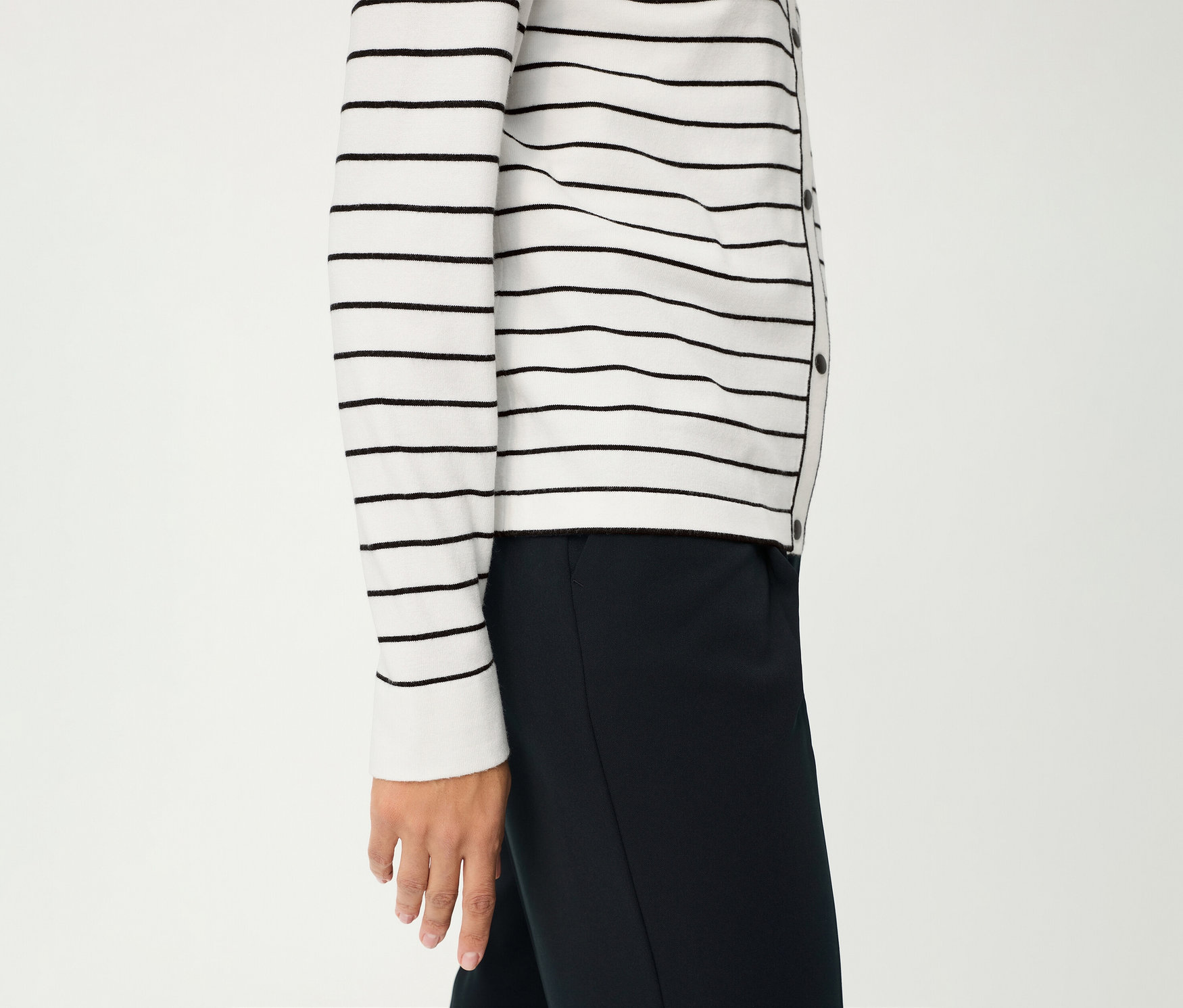Person trägt einen gestreiften Olsen Cardigan »LA« und eine dunkle Hose vor einem weißen Hintergrund.