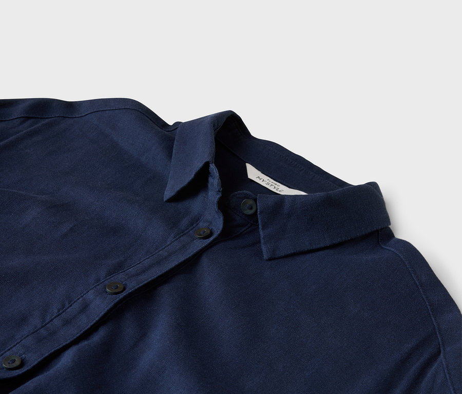 Nahaufnahme eines dunkelblauen Hemdes mit Kragen und Knöpfen.