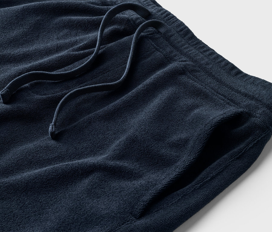 Nahaufnahme einer marineblauen Frotteeshorts mit Kordelzug und Tasche.