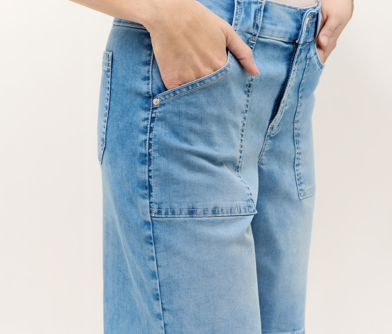 Person mit Angels Denim »Lia Urban« Shorts, blau, mit Händen in den Taschen.