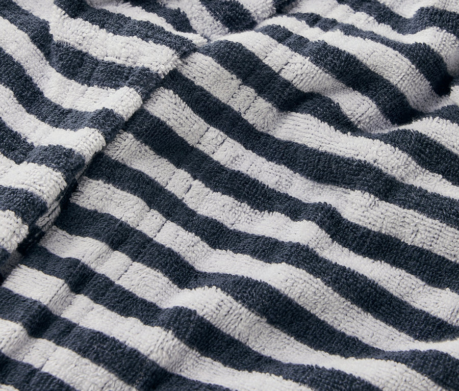 Nahaufnahme eines gestreiften Handtuchs mit marineblauen und weißen Streifen.