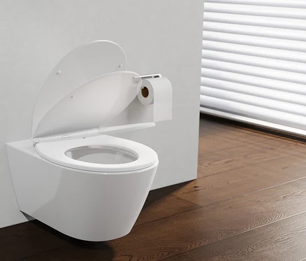 Weißes wandhängendes WC mit geöffnetem WC-Sitz „PREMIUM“ und Deckel, daneben ein Toilettenpapierhalter mit Rolle, auf dunklem Holzboden vor einem Fenster mit weißen Jalousien.