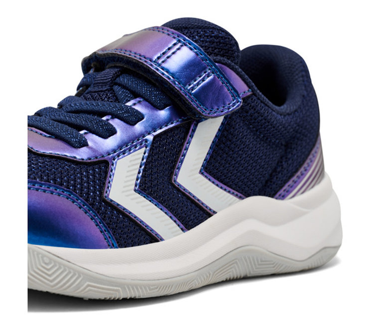 Dunkelblauer Kindersneaker mit irisierenden violetten Details, weißen Chevron-Streifen, einem Klettverschluss und einer dicken weißen Sohle mit grauer, strukturierter Unterseite.