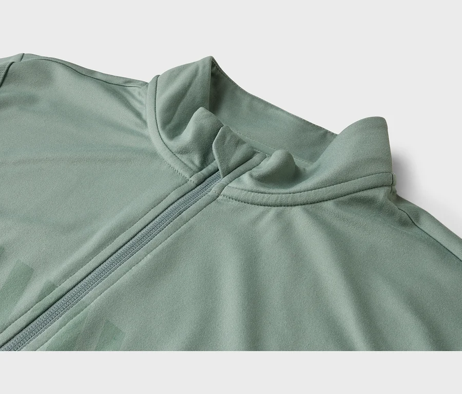 Nahaufnahme einer hellgrünen Jacke mit Stehkragen und halbem Reißverschluss.