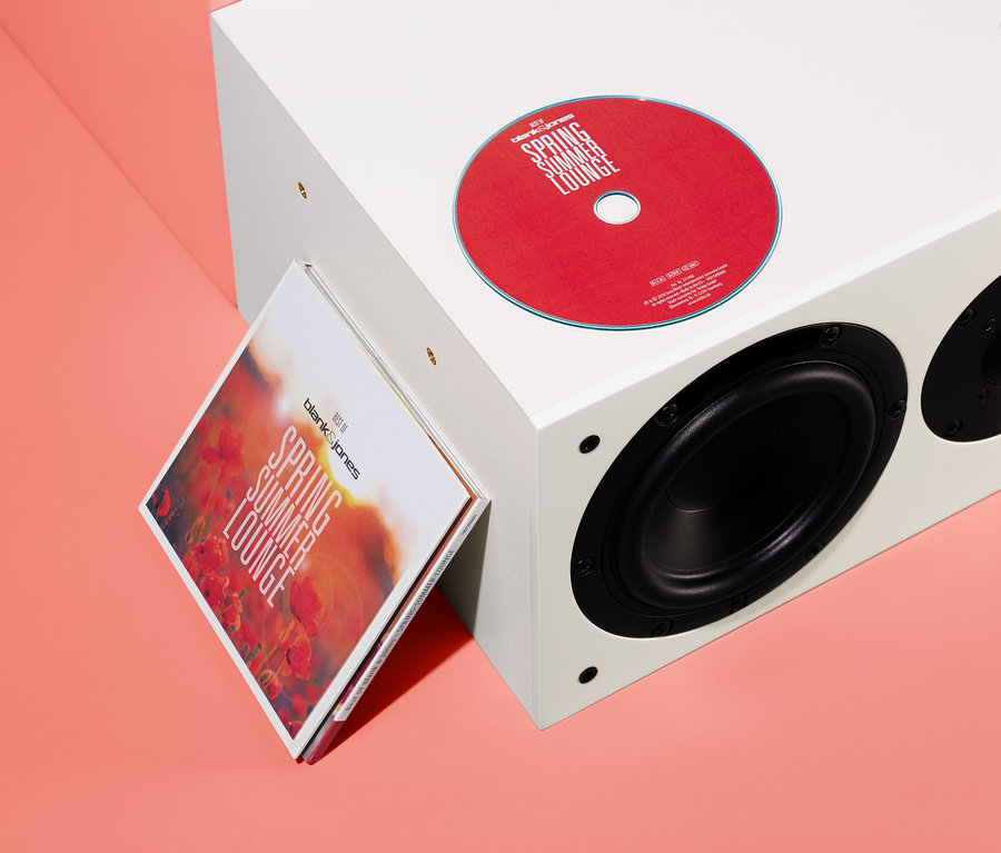 Eine rote CD und die CD-Hülle »Best of Blank & Jones: Spring Summer Lounge« lehnen an einem weißen Lautsprecher.