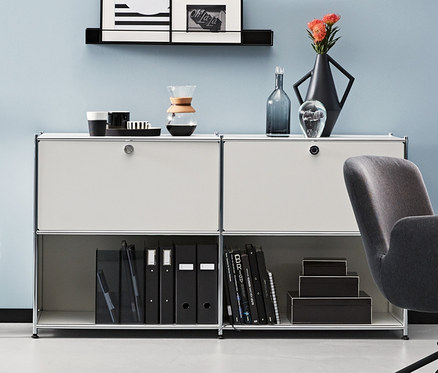 Ein Zimmer mit einem anthrazitfarbenen Schreibtischstuhl und Metall-Sideboards. Ein anthrazitfarbenes und zwei weiße Metall-Sideboards CN3 mit 2 versetzbaren Klappenfächern.