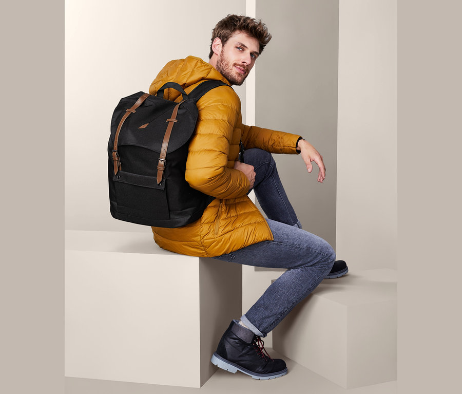 Mann sitzt mit Heritage-Rucksack.
